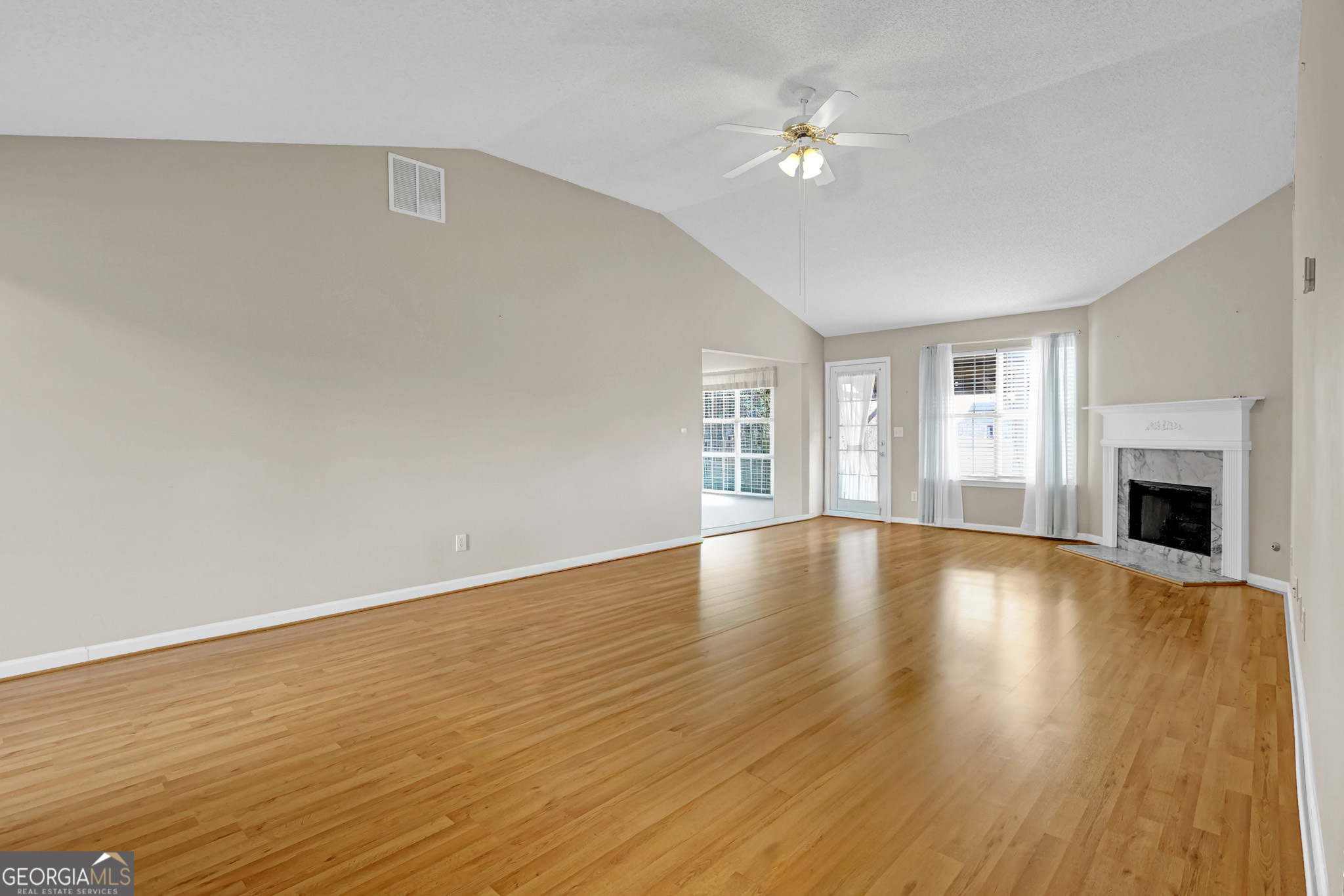313 Harris Avenue Locust Grove, GA 30248 - Photo 13 of 34 a view of an empty room with window and wooden floor