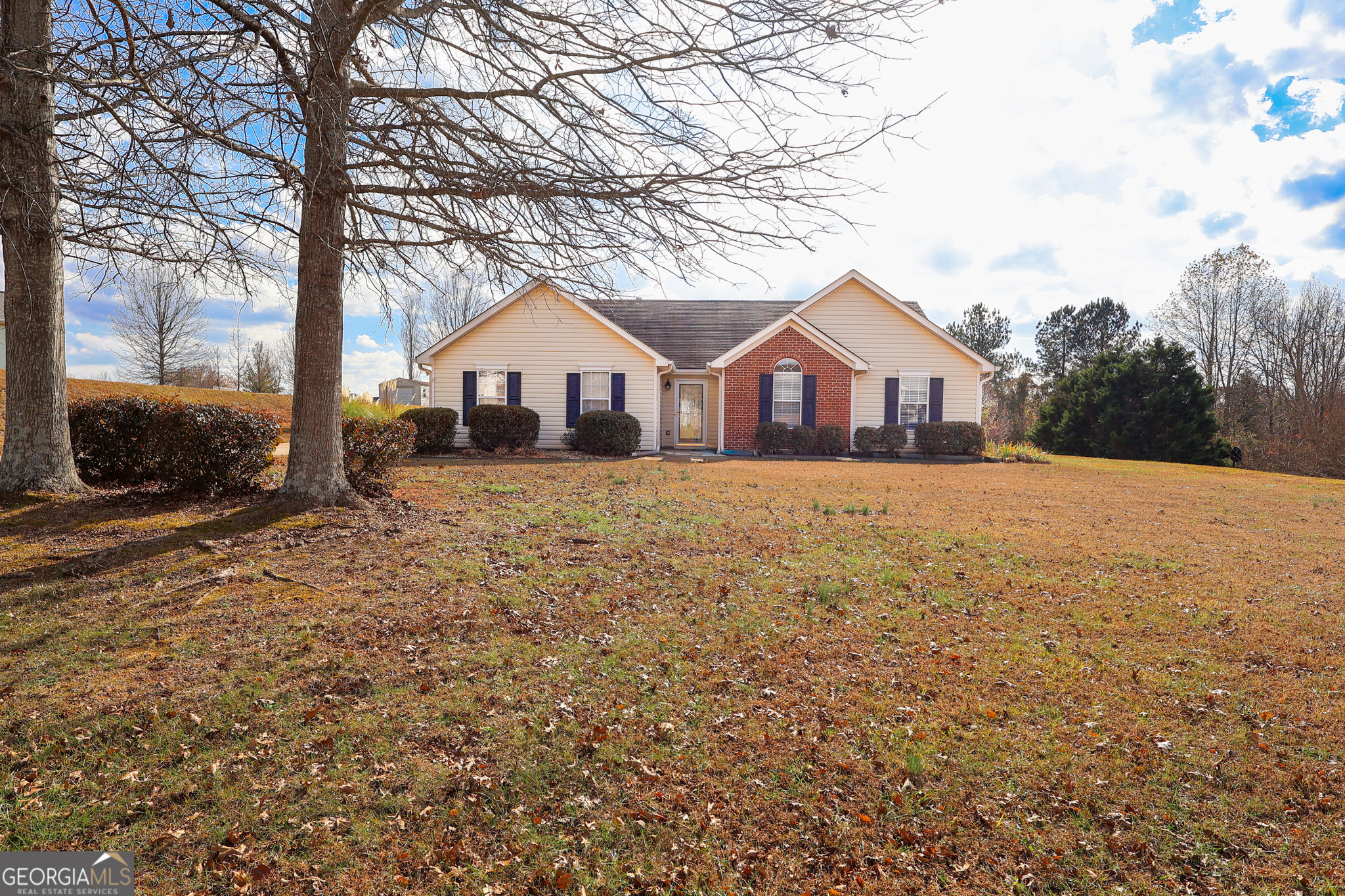 313 Harris Avenue Locust Grove, GA 30248 - Photo 2 of 34 a house with a large tree in front of it