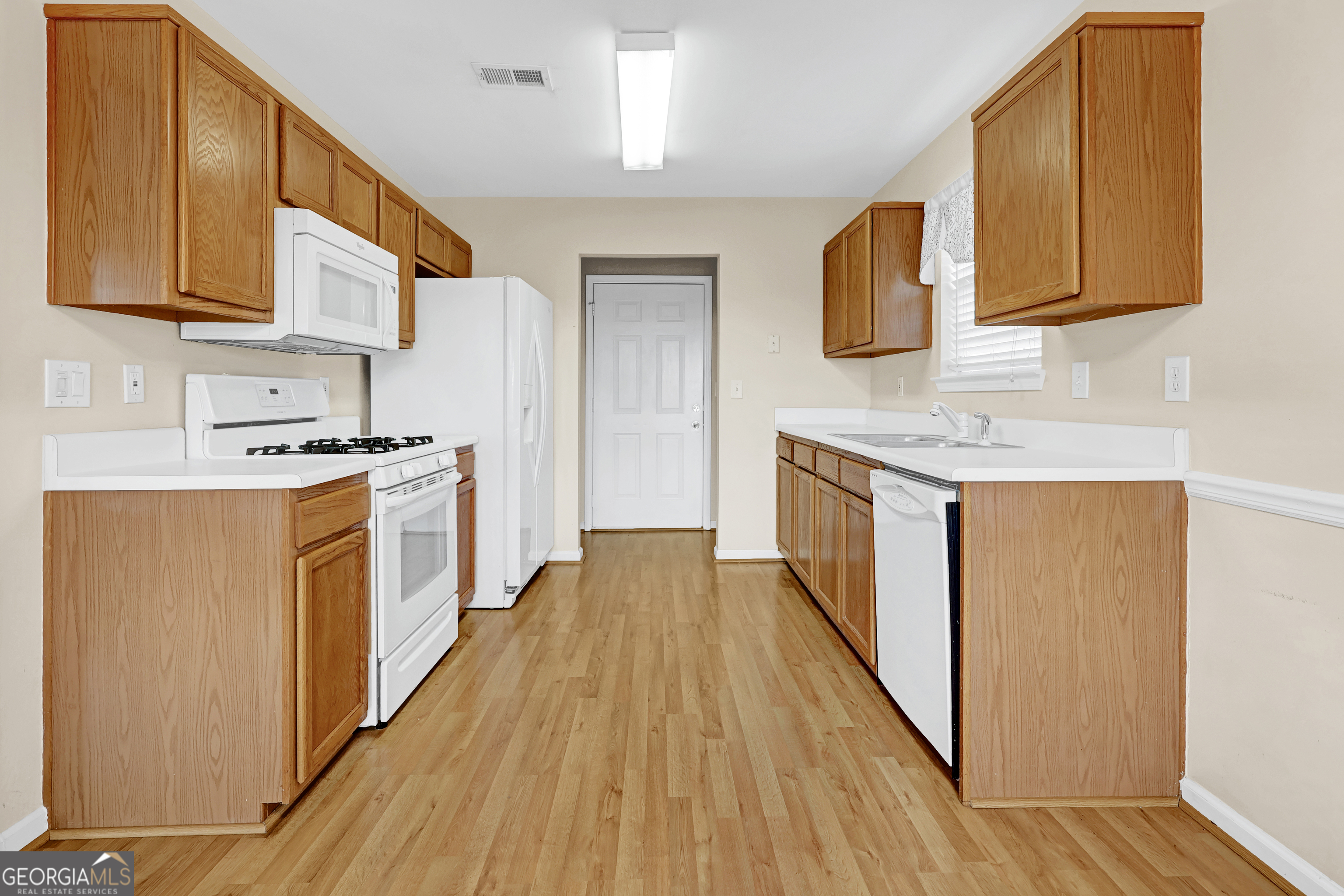313 Harris Avenue Locust Grove, GA 30248 - Photo 23 of 34 a kitchen with stainless steel appliances granite countertop wooden cabinets a stove a sink and a wooden floors