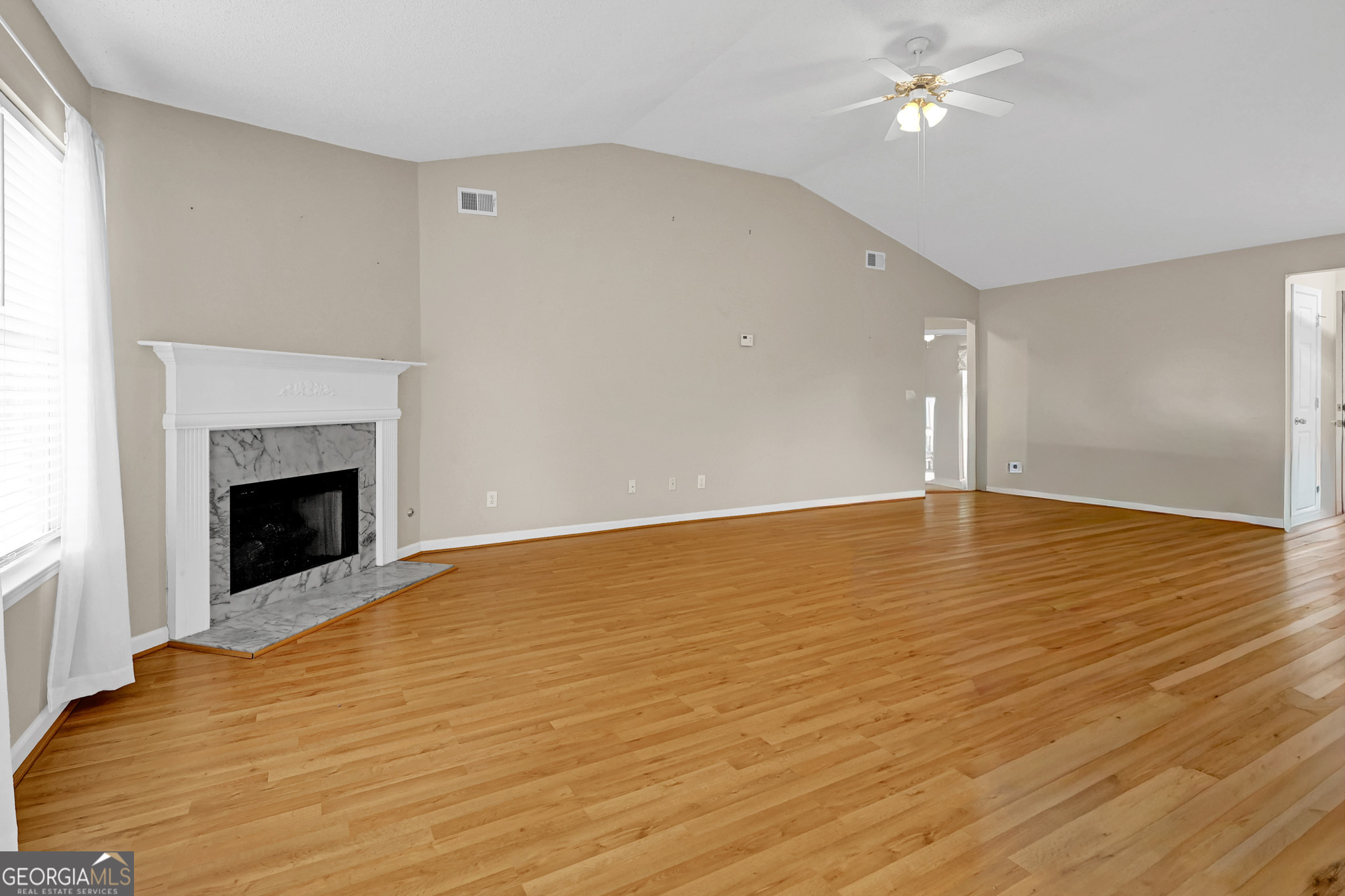 313 Harris Avenue Locust Grove, GA 30248 - Photo 30 of 34 a view of an empty room with wooden floor and a fireplace