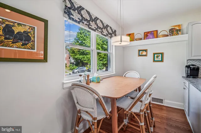a view of a dining room with furniture a rug and wooden floor