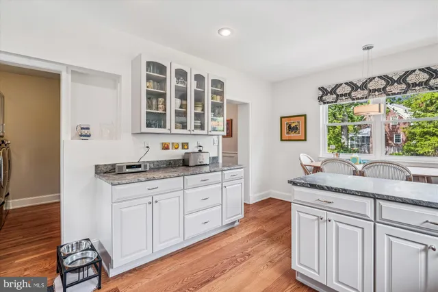 a kitchen with granite countertop white cabinets and window