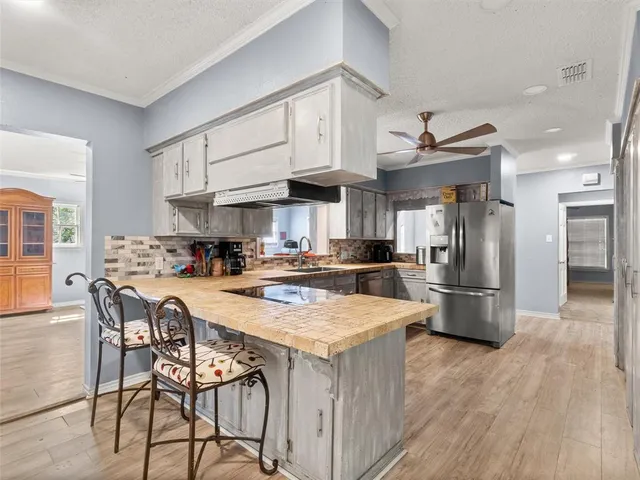 a kitchen with stainless steel appliances granite countertop a table chairs and a refrigerator