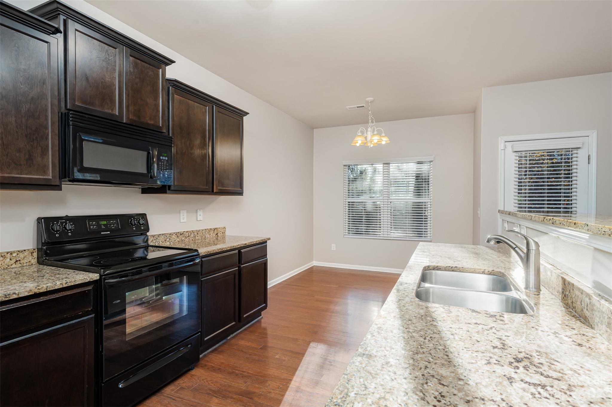13225 Chelsea Ridge Lane Huntersville, NC 28078 - Photo 15 of 40 a kitchen with granite countertop wooden cabinets stainless steel appliances and a window