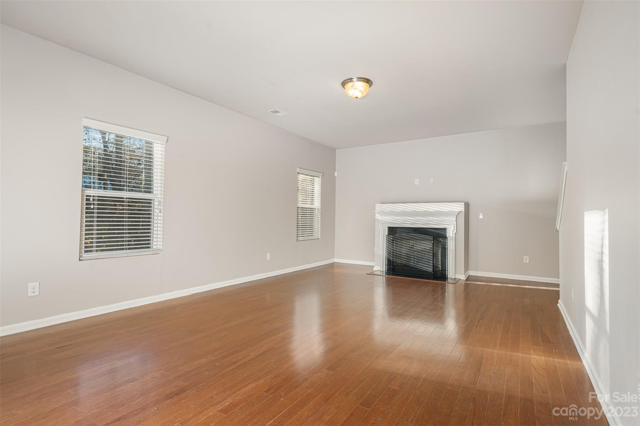 13225 Chelsea Ridge Lane Huntersville, NC 28078 - Photo 7 of 40 an empty room with wooden floor fireplace and windows