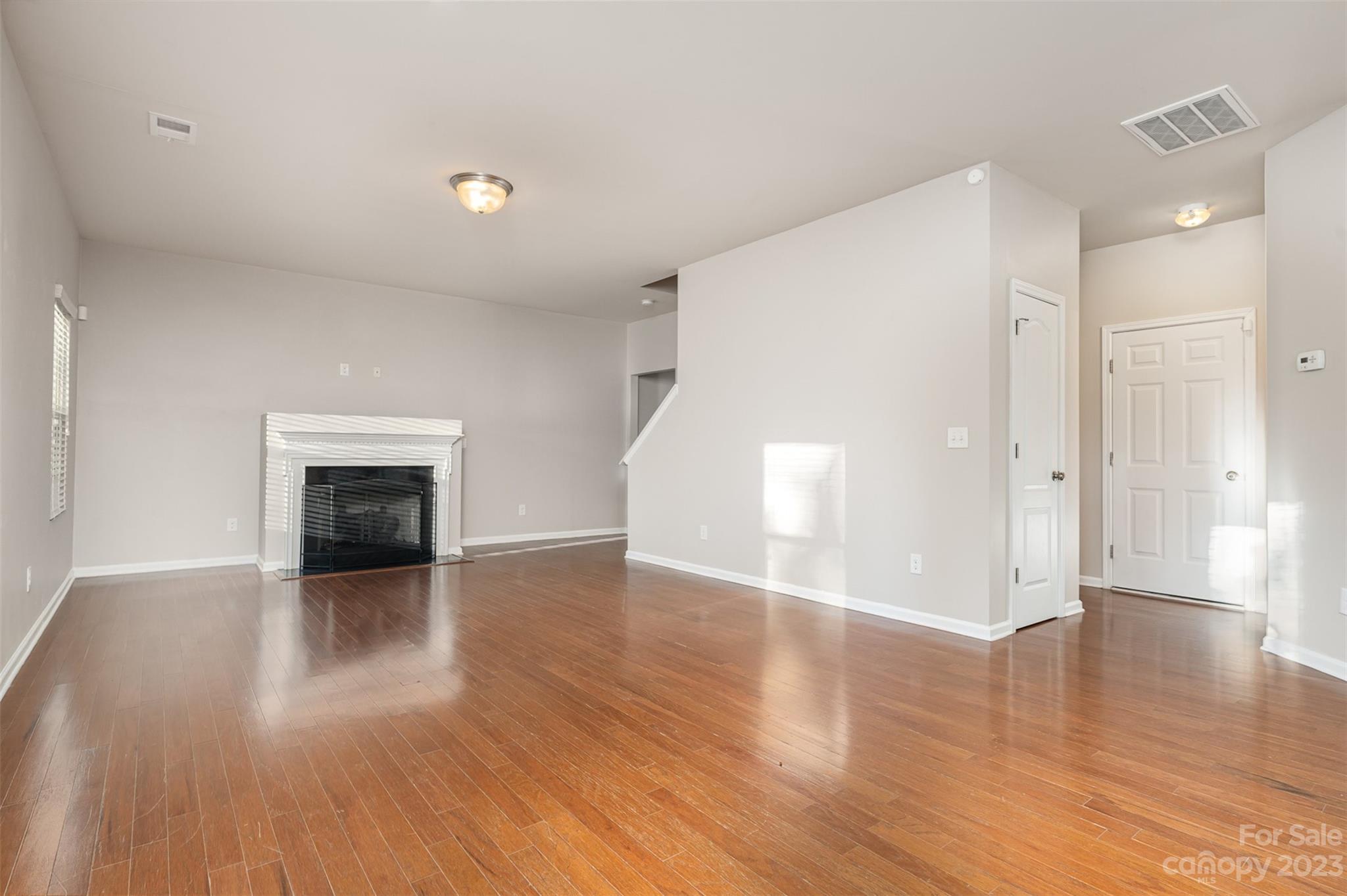 13225 Chelsea Ridge Lane Huntersville, NC 28078 - Photo 8 of 40 an empty room with wooden floor and a fireplace