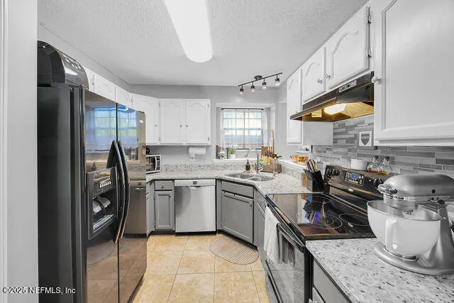 a kitchen with stainless steel appliances granite countertop a sink stove and cabinets