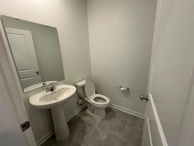 a bathroom with a sink toilet and a mirror