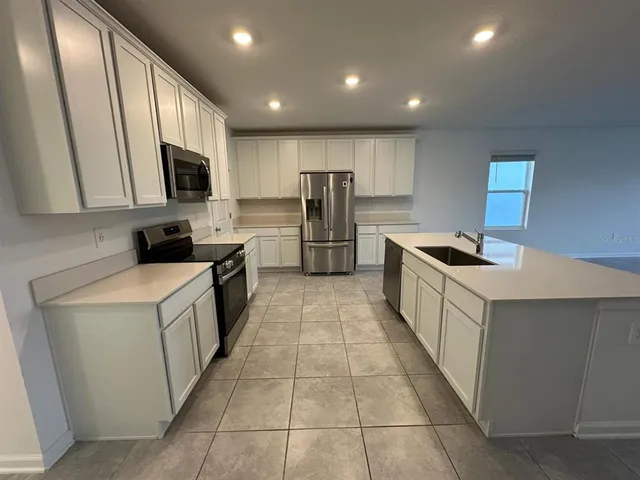 a kitchen with stainless steel appliances a refrigerator and a stove top oven