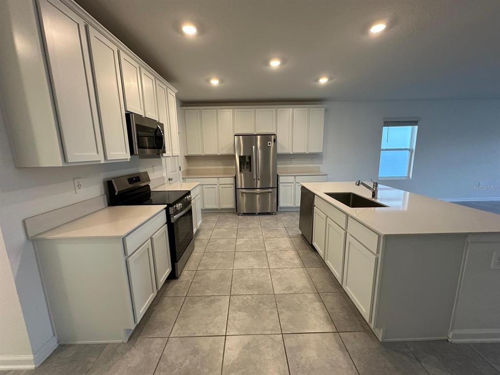 2275 Pocky Way Kissimmee, FL 34746 - Photo 3 of 25 a kitchen with stainless steel appliances a refrigerator and a stove top oven