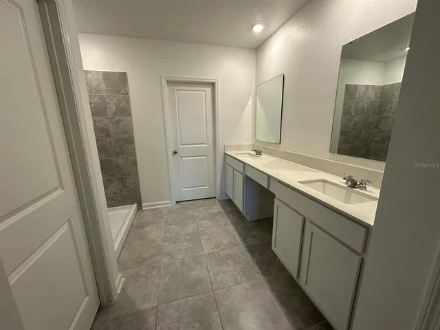 a bathroom with a tub sink and mirror