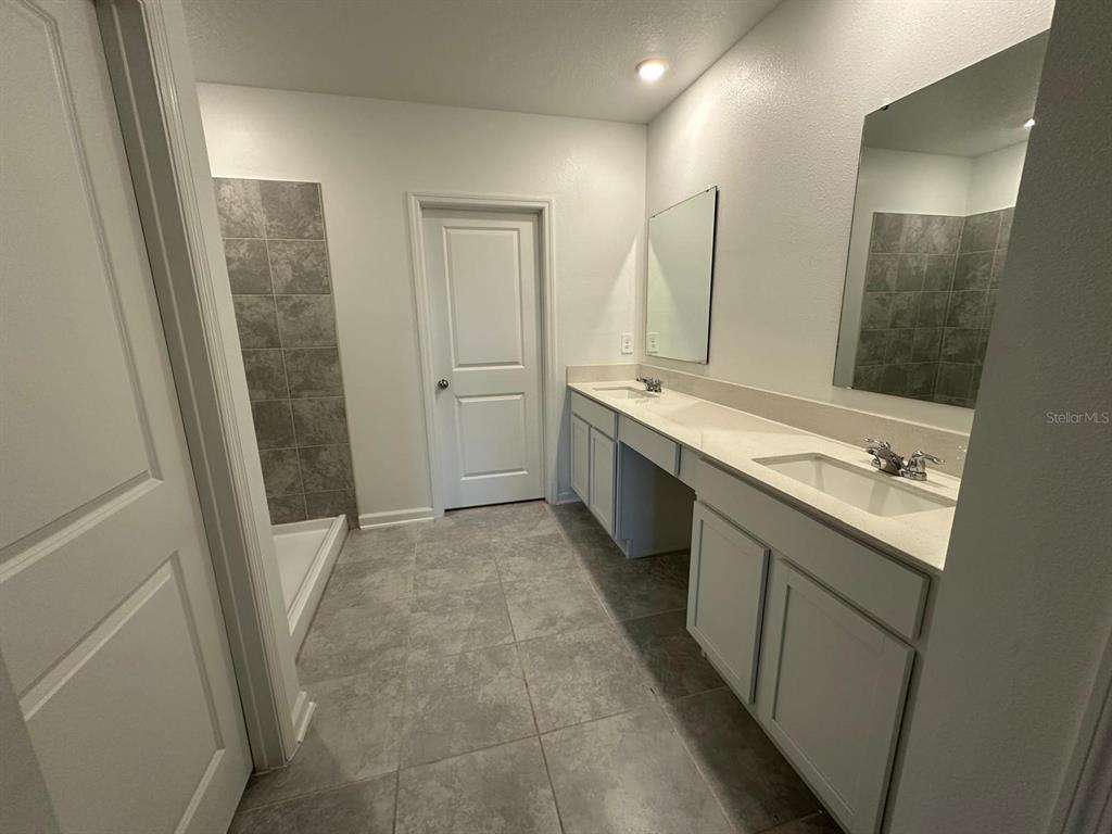 2275 Pocky Way Kissimmee, FL 34746 - Photo 8 of 25 a bathroom with a tub sink and mirror