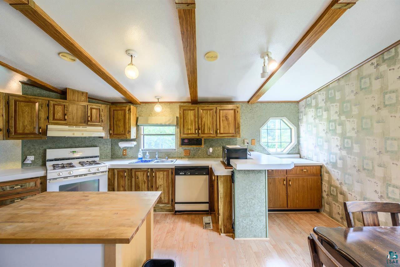 705 4th Street North Biwabik, MN 55708 - Photo 6 of 29 Kitchen featuring wood-finish cabinetry, a gas range, a dishwasher, and a double basin sink