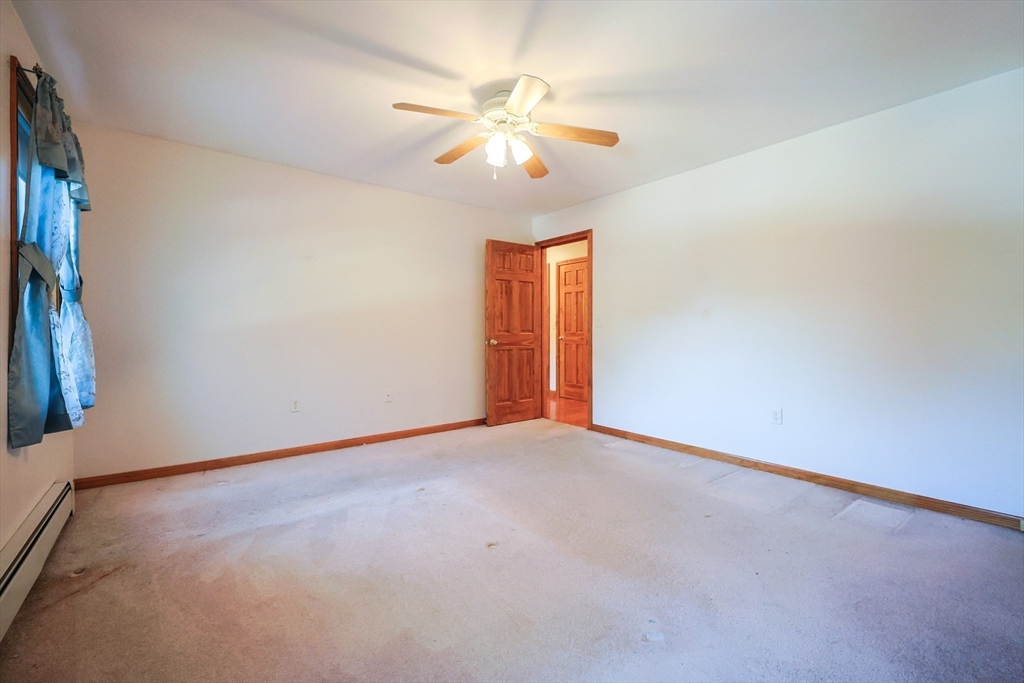 1380 North Brookfield Road Oakham, MA 01068 - Photo 19 of 37 an empty room with a chandelier fan and windows