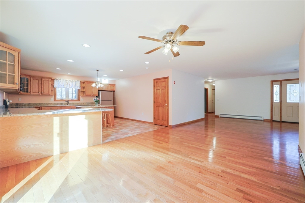 1380 North Brookfield Road Oakham, MA 01068 - Photo 10 of 37 a view of a kitchen and an empty room with wooden floor