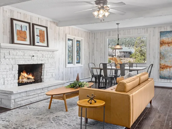 a living room with furniture a chandelier and a fireplace