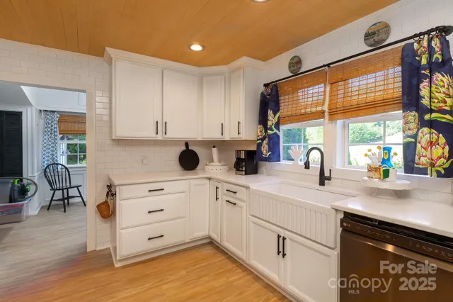 a kitchen with stainless steel appliances kitchen island granite countertop a stove a refrigerator a microwave oven with a dining table and chairs with wooden floor