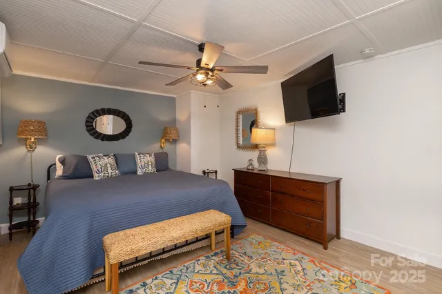 a bedroom with a bed a chandelier and dresser