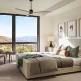 a bedroom with a bed and large windows