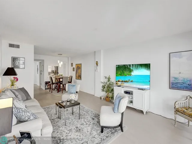 a living room with furniture a flat screen tv and a large window