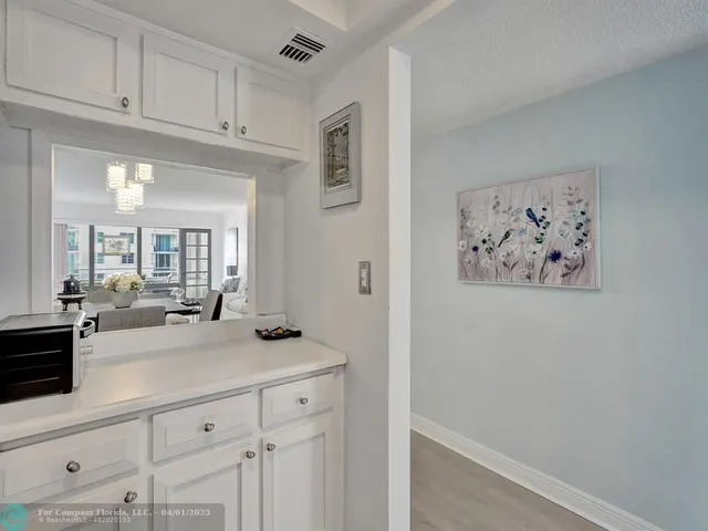 a view of a hallway to a kitchen and a window
