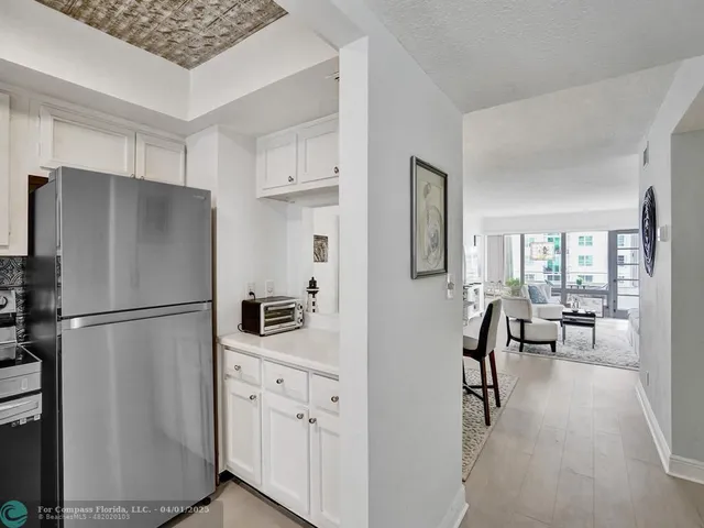 a kitchen with stainless steel appliances a refrigerator a stove a sink a dining table and chairs