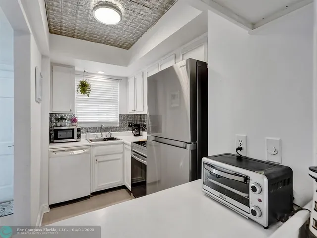 a kitchen with stainless steel appliances a stove a refrigerator and white cabinets