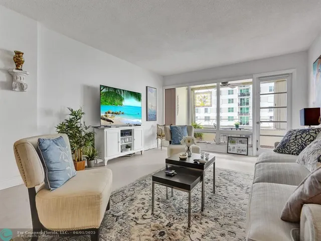 a living room with furniture a flat screen tv and a large window