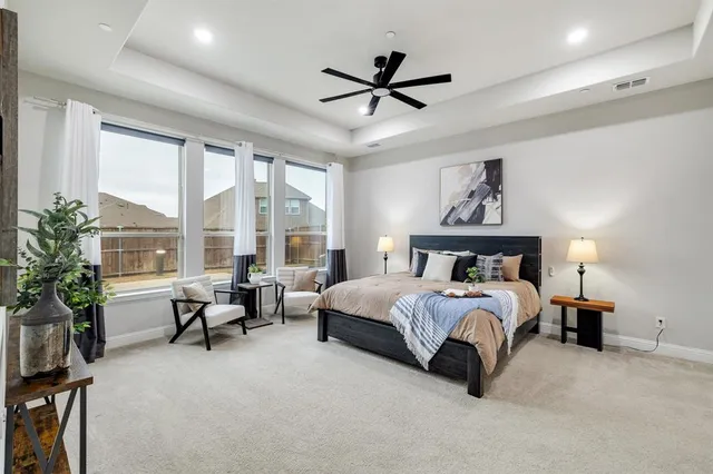 a spacious bedroom with a bed couch and a large window