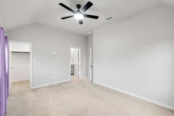 an empty room with a ceiling fan and a window