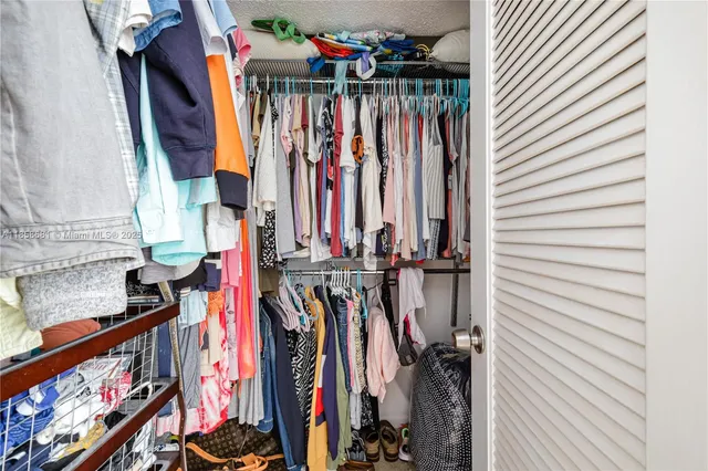 a view of walk in closet with clothes