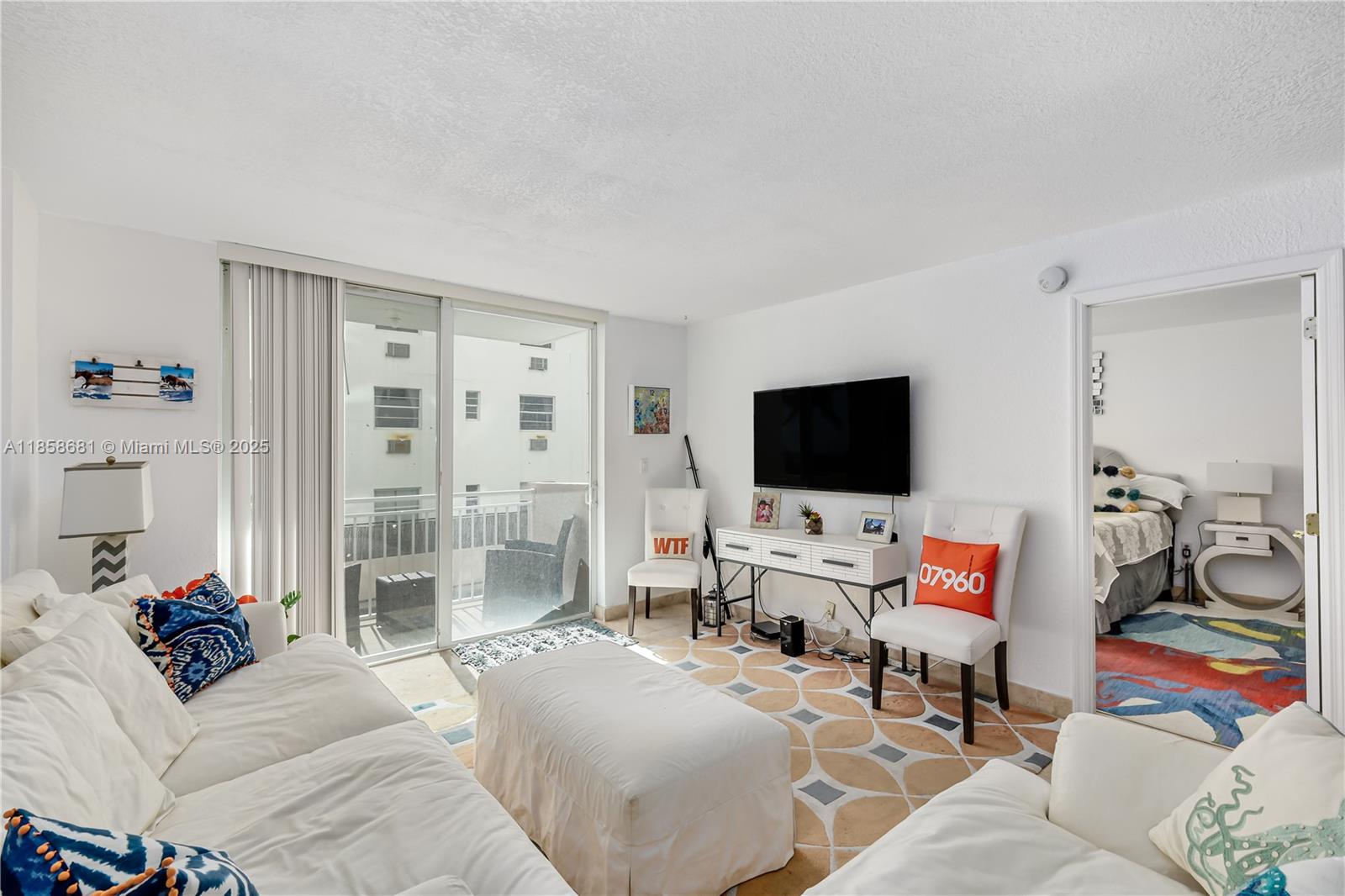 345 Ocean Drive, Unit 211 Miami Beach, FL 33139 - Photo 3 of 27 a bedroom with furniture and a flat screen tv