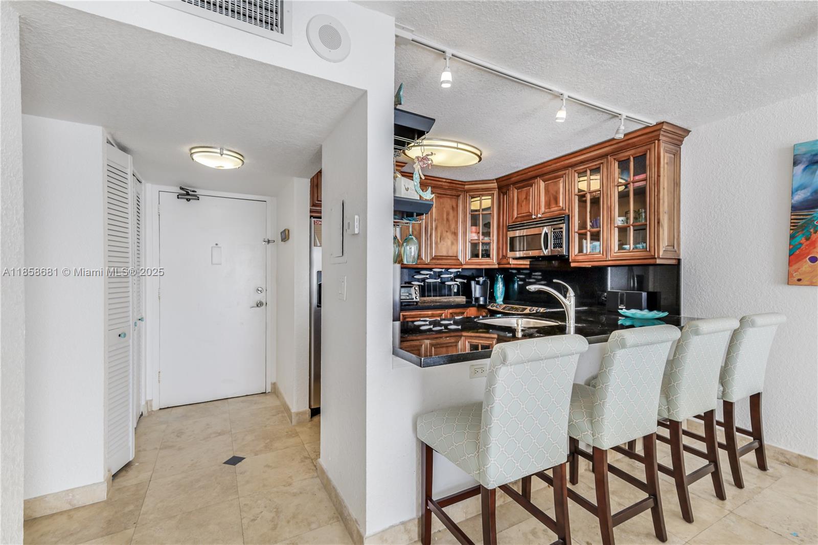 345 Ocean Drive, Unit 211 Miami Beach, FL 33139 - Photo 8 of 27 a kitchen with stainless steel appliances kitchen island granite countertop a refrigerator and a stove top oven