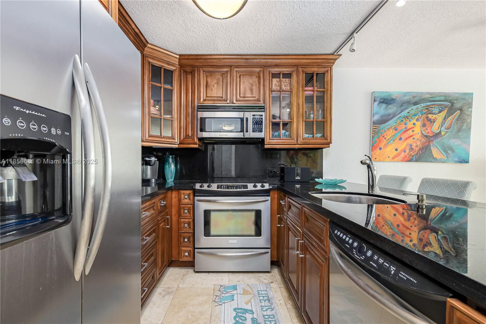345 Ocean Drive, Unit 211 Miami Beach, FL 33139 - Photo 9 of 27 a kitchen with stainless steel appliances granite countertop a stove and a refrigerator