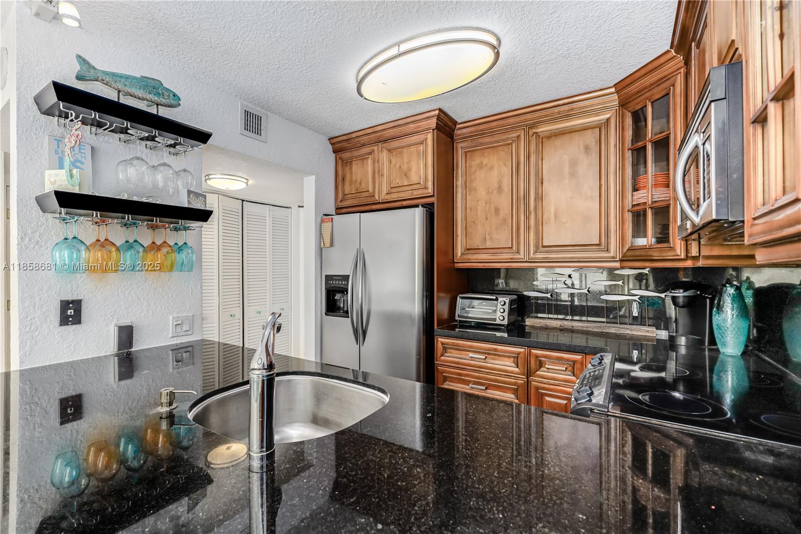 345 Ocean Drive, Unit 211 Miami Beach, FL 33139 - Photo 10 of 27 a kitchen with stainless steel appliances granite countertop a sink refrigerator and cabinets
