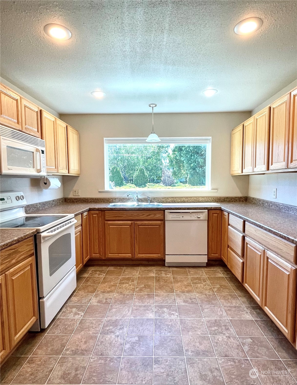 47 Kermel Road Omak, WA 98841 - Photo 7 of 40 a kitchen with stainless steel appliances a stove a sink and a microwave
