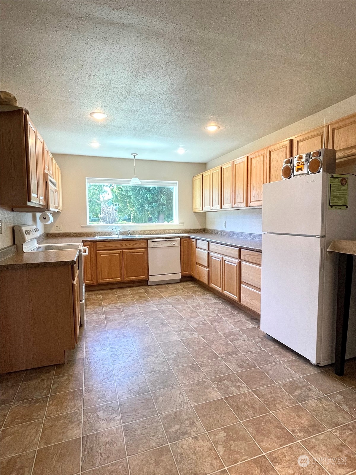 47 Kermel Road Omak, WA 98841 - Photo 9 of 40 a kitchen with stainless steel appliances granite countertop a refrigerator a stove a sink a microwave and island