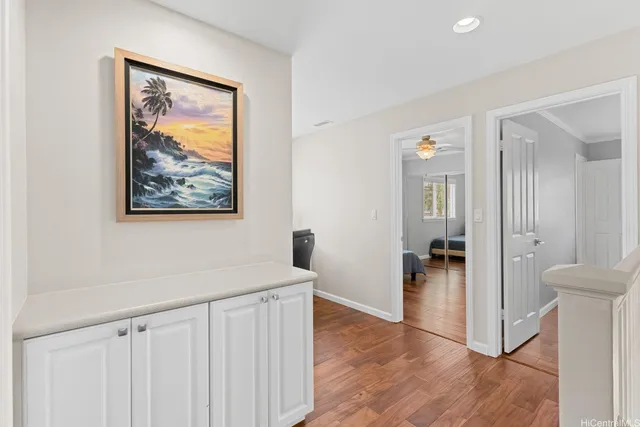 a view of a hallway with wooden floor and furniture