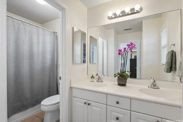 a bathroom with a double vanity sink mirror and toilet