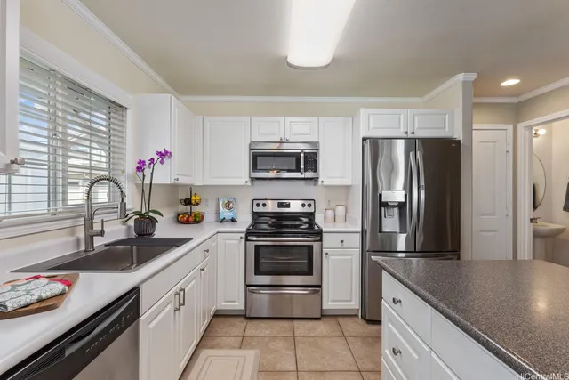 a kitchen with granite countertop a refrigerator stove and sink