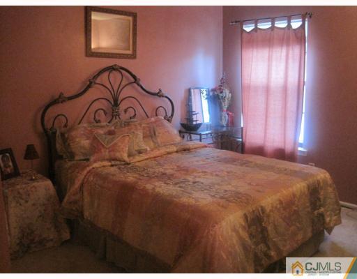 1405 Timber Oaks Road Edison, NJ 08820 - Photo 8 of 10 a bedroom with a bed and a night stand