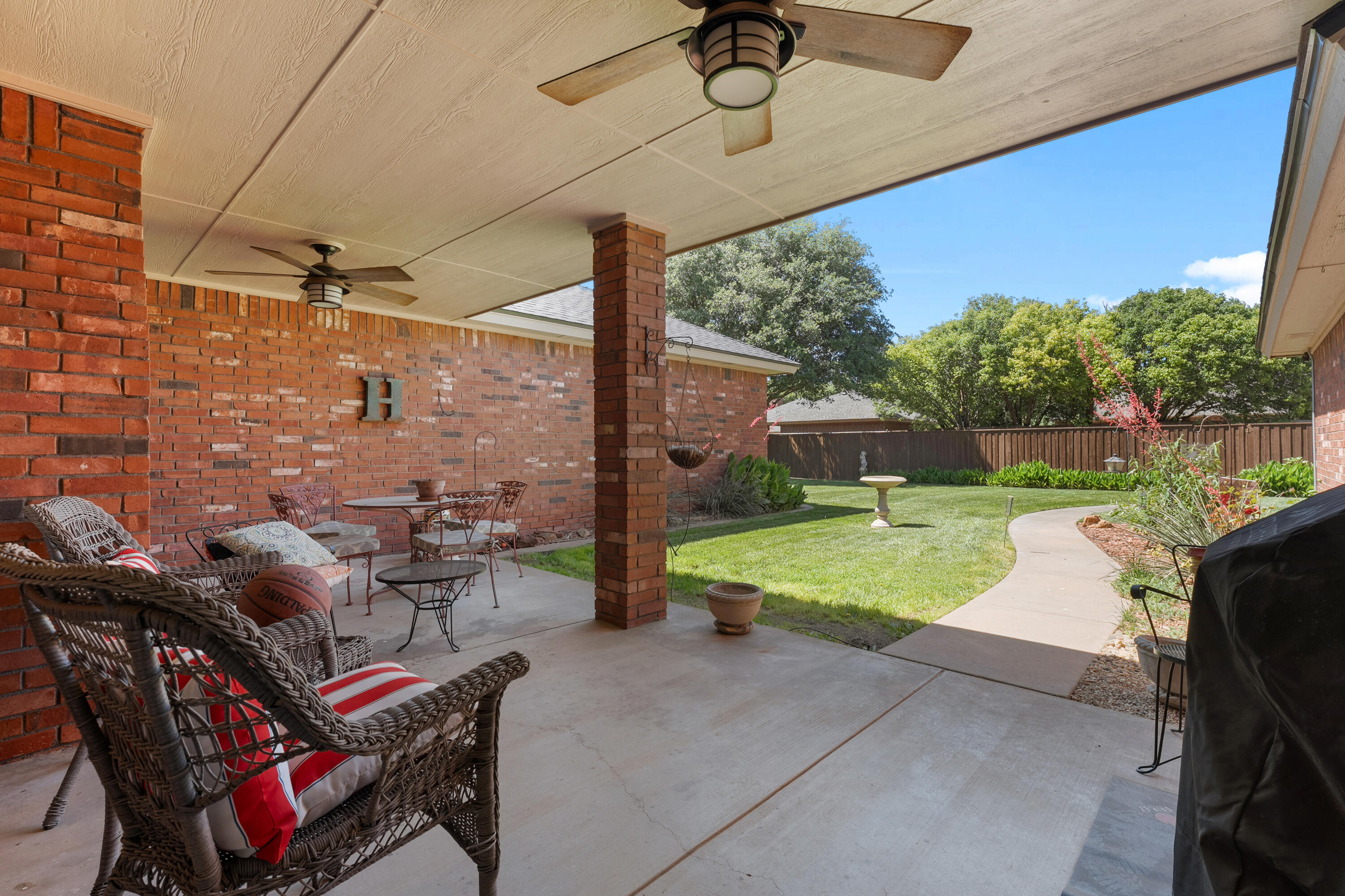 7402 95th Street Lubbock, TX 79424 - Photo 36 of 43 a patio with lawn chairs and outdoor kitchen