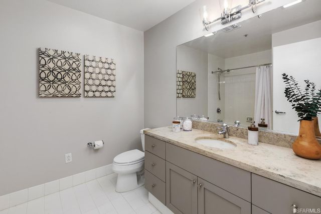 a bathroom with a granite countertop sink mirror and toilet