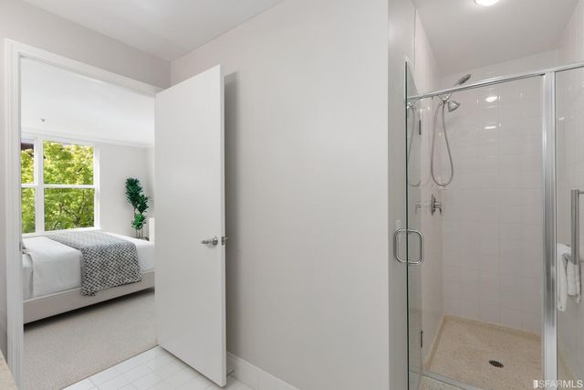 a en suite bathroom with a shower sink and mirror