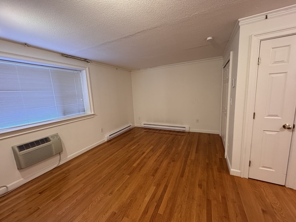 1691 Cambridge Street, Unit 22 Cambridge, MA 02138 - Photo 6 of 17 a view of a room with wooden floor and white walls