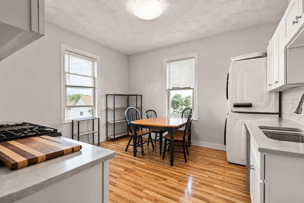 39 Union Street Boston, MA 02135 - Photo 12 of 33 a kitchen with a stove a sink dishwasher a dining table and chair with wooden floor
