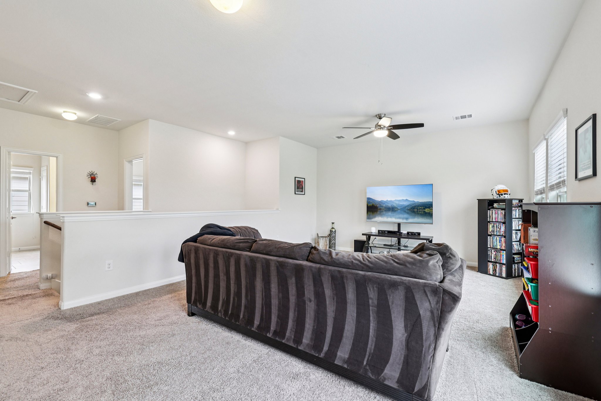 10033 Gertrudis Loop Austin, TX 78747 - Photo 13 of 39 The property features a bright living area with light-colored carpeting, a ceiling fan, and recessed lighting