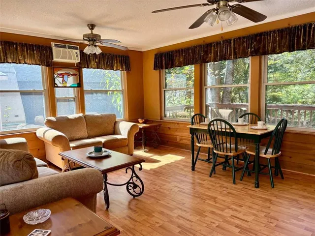 a kitchen that has a sink a stove wooden floor and a dining table
