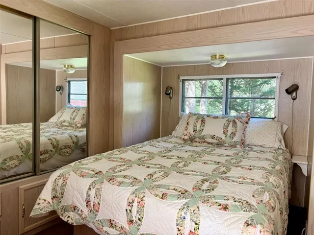 a view of a park with large trees and a wooden fence