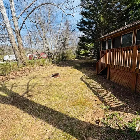 a view of a wooden deck with chairs and a yard